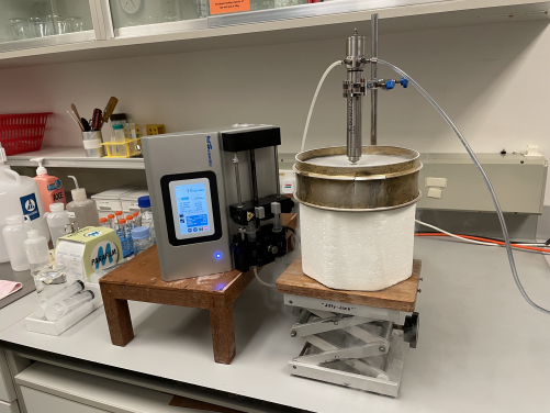 Photos of ‘spray-freezing’ step in spray freeze drying process. Liquid is fed into a nozzle and atomised into fine droplets. Those droplets fall into liquid nitrogen (inside the white styrofoam container) and become frozen.